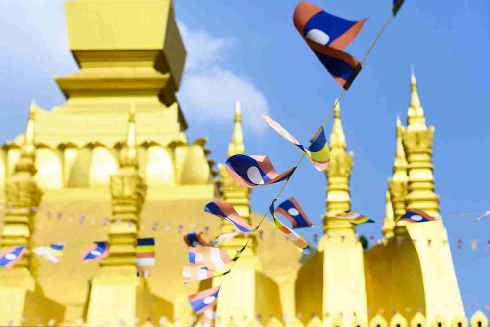 De petits drapeaux laotiens décorent un temple.